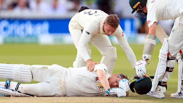 Players from both sides check on Steve Smith after he is felled by a Jofra Archer bouncer.