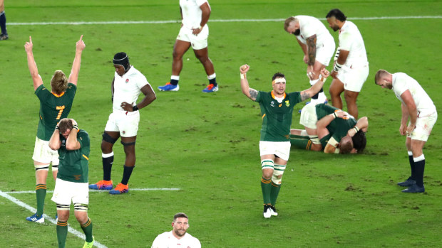 Players of South Africa celebrate victory as the England team react to defeat as referee Jerome Garces blows his whistle during the Rugby World Cup 2019 final.