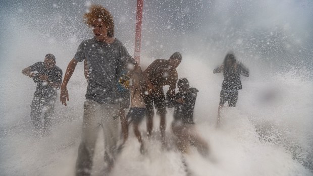 Big wave spectators almost get washed off the Brunswick Heads rockwall as massive swell and destructive winds hammer the NSW North East as Cyclone Alfred gets closer.