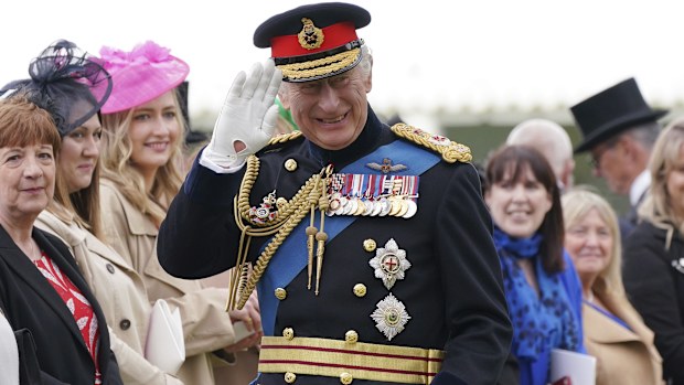 King Charles III waves as he meets guests after a ceremony to present new Standards and Colours to the Royal Navy, the Life Guards of the Household Cavalry Mounted Regiment, The King's Company of the Grenadier Guards and The King's Colour Squadron of the Royal Air Force at Buckingham Palace in London, Thursday April 27, 2023 