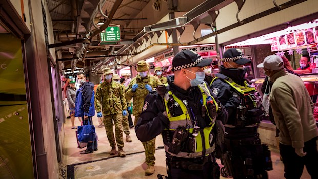 Members of Victoria Police aided by ADF soldiers patrol the Queen Victoria Market in Melbourne