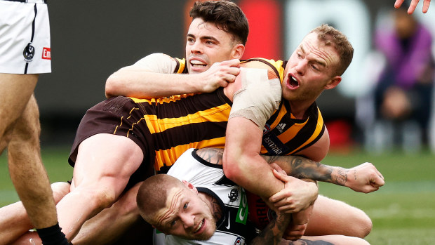 Tom Mitchell and Conor Nash of the Hawks and Jordan De Goey of the Magpies