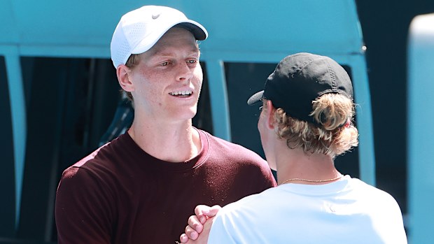 Jannik Sinner of Italy and Cruz Hewitt of Australia shake hands following a practice session.