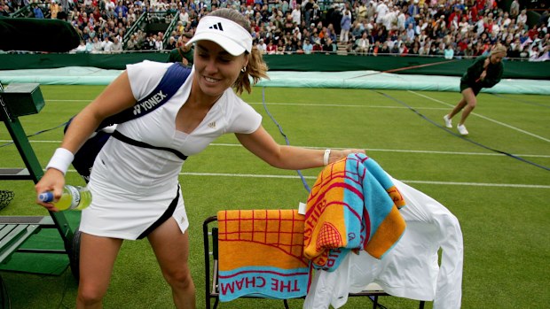 Martina Hingis of Switzerland grabs her equipment after the umpire stops play for a rain delay.