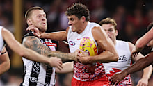 Charlie Curnow of the Swans fends Jordan De Goey of the Magpies.