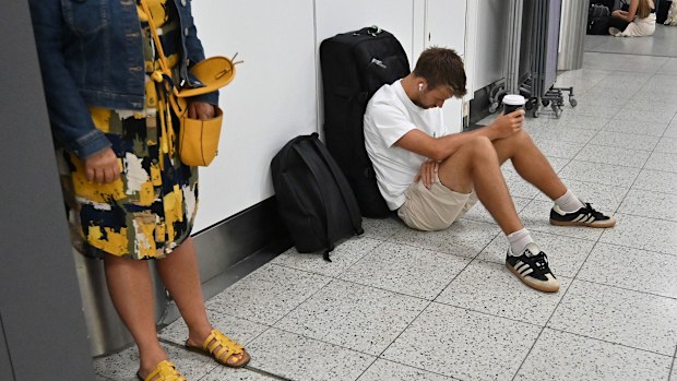 A passenger waits in the check-in area of Gatwick Airport as some flights are cancelled or delayed, in Horley, south of London on July 20.