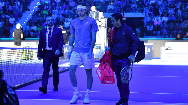 Stefanos Tsitsipas looks dejected after retiring from his round-robin match against Holger Rune at the ATP Finals.