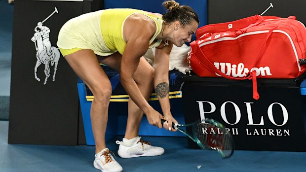 Aryna Sabalenka smashes her racquet after her loss.