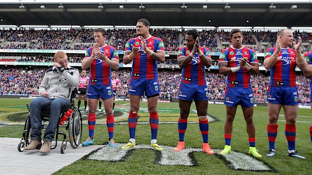 Knights oyuncuları, 2014'te Rise For Alex sırasında Alex McKinnon'u alkışlıyor.