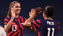 SAITAMA, JAPAN - JULY 24: Alex Morgan #13 of Team United States celebrates their side's sixth goal, an own goal by Catherine Bott #4 of Team New Zealand with team mate Christen Press #11 during the Women's First Round Group G match between New Zealand and United States on day one of the Tokyo 2020 Olympic Games at Saitama Stadium on July 24, 2021 in Saitama, Japan. (Photo by Francois Nel/Getty Images)