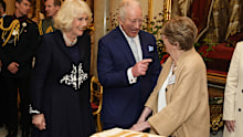 King Charles III and Queen Camilla cut a cake with 100 year-old Joan Illingworth during a reception at Buckingham Palace, on the 100th anniversary of the birth of Queen Elizabeth II on April 21, 2026 in London