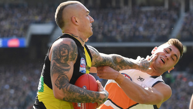 Dustin Martin of the Tigers fends off a tackle by Tim Taranto of the Giants during the 2019 AFL Grand Final match between the Richmond Tigers and the Greater Western Sydney Giants at Melbourne Cricket Ground on September 28, 2019 in Melbourne, Australia. (Photo by Quinn Rooney/Getty Images)