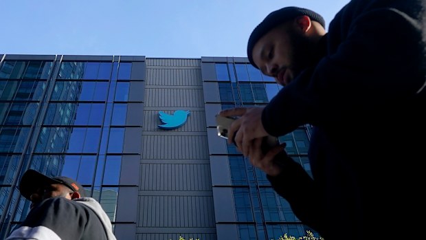 People walk outside Twitter headquarters in San Francisco, Friday, Nov. 4, 2022. 