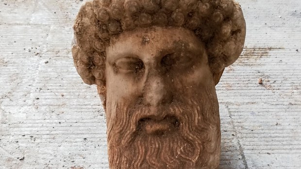In this undated photo, provided by the Greek Culture Ministry a head of the ancient god Hermes is pictured after being found during sewage works in central Athens. The ministry said Sunday that the head, depicting Hermes at a "mature age", one of many that served as street markers in ancient Athens, appears to be from around 300 BC, that is, either from the late 4th century BC, or the early 3rd century. 