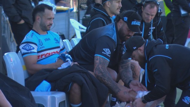 Braydon Trindall of the Cronulla Sharks sits on the sidelines icing his foot.