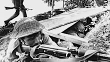 A Pakistani soldier aims his rifle as a fellow soldier runs for cover during Indian shelling of Pakistani positions in the Jessore area of East Pakistan on December 2, 1971.