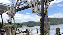 A handmade arch lovingly built has been erected on the banks of the river where you can eat fresh food and take in the scene.