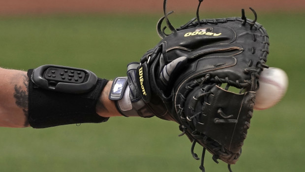 Seattle Mariners catcher Tom Murphy wears a wrist-worn device used to call pitches during a spring training baseball game.