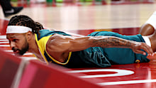 Patty Mills slides along the floor after taking contact.