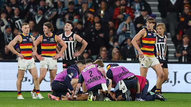 Medal staff assist Izak Rankine of the Crows following an incident with Dan Houston of the Power.