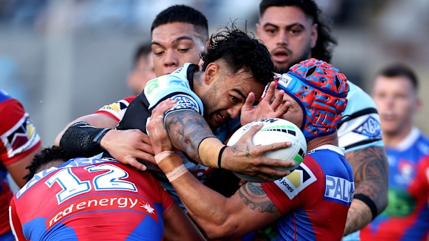 Briton Nikora of the Sharks is tackled by the Knights' defence.