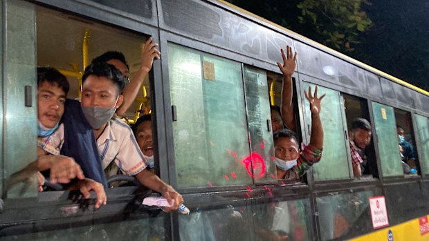 People wave from a bus after being released from Insein Prison in Yangon. 