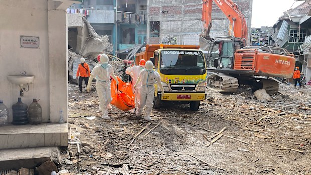 Rescuers carry the body of a newly recovered victim of a building that collapsed at an Islamic boarding school in Sidoarjo, East Java, Indonesia, Sunday, Oct. 5, 2025. (AP Photo/Trisnadi)