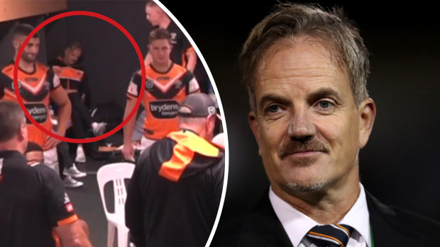 Tigers CEO Justin Pascoe (right) and circled (left) in the dressing room during the club's loss to the Broncos.
