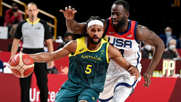 Boomers star Patty Mills is guarded by Draymond Green.