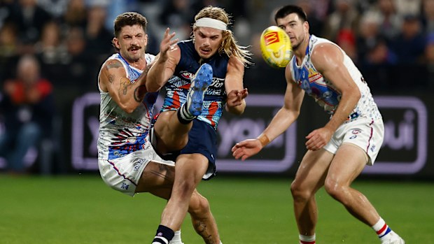 Bailey Smith of the Cats is tackled by Tom Liberatore of the Bulldogs.