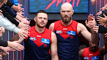 Steven May and Max Gawn lead the Demons players out.