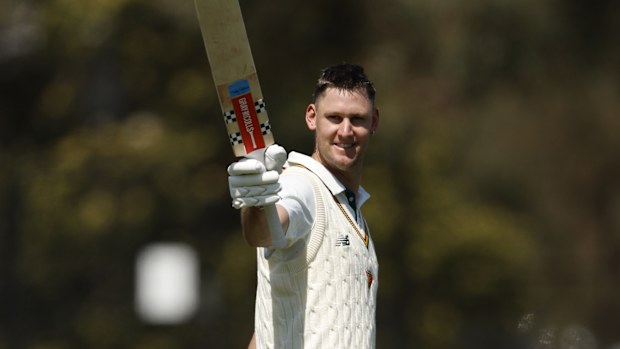 Beau Webster of Tasmania raises his bat after scoring 100 at CitiPower Centre.