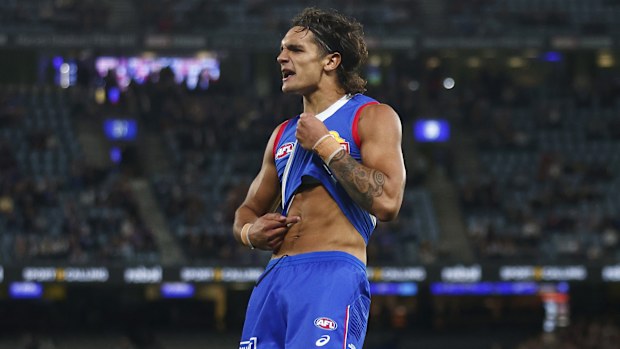 Jamarra Ugle-Hagan of the Bulldogs points to his skin as he celebrates kicking a goal against the Lions at Marvel Stadium.
