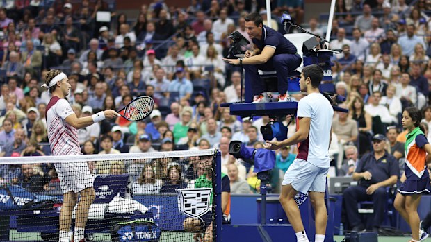 Casper Ruud of Norway and Carlos Alcaraz of Spain talk with the chair umpire Nico Helwerth about a play during their men's singles final at the 2022 US Open. 
