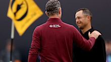 Xander Schauffele of the United States and Justin Rose of England embrace on the 18th green.