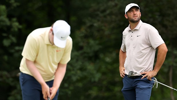 Scottie Scheffler watches on as Robert MacIntyre putts on the first green during the third round of the 2025 BMW Championship.