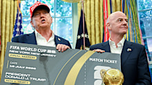 US president Donald Trump and FIFA president Gianni Infantino display the ceremonial first ticket for the 2026 World Cup final.