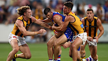 Matthew Kennedy of the Bulldogs is tackled by Josh Weddle and Jai Newcombe of the Hawks.