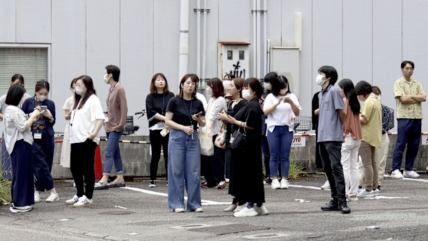 People take shelter outside building following an earthquake in Miyazaki, western Japan, Thursday, Aug. 8, 2024.(Kyodo News via AP)