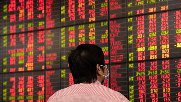 A Thai investor look in front of an electronic board showing stock prices after hares plunged on Friday, with benchmarks in Japan, Thailand and India sinking as much as 10%.