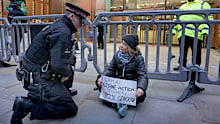 In this photo, released by 'Prisoners for Palestine' on Tuesday, December 23, 2025, climate activist Greta Thunberg, centre, sits in front of offices of Aspen Insurance in London, England, during a protest to support the Palestine Action protesters on hunger strike in prison.