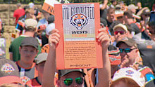 A Tigers fan holds up a flyer calling for the Holman Barnes Group to be held accountable.