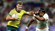 Nick Malouf of Australia holds off a tackle from Maka Unufe from the United States during the men's rugby sevens quarter-final match between at Stade de France.