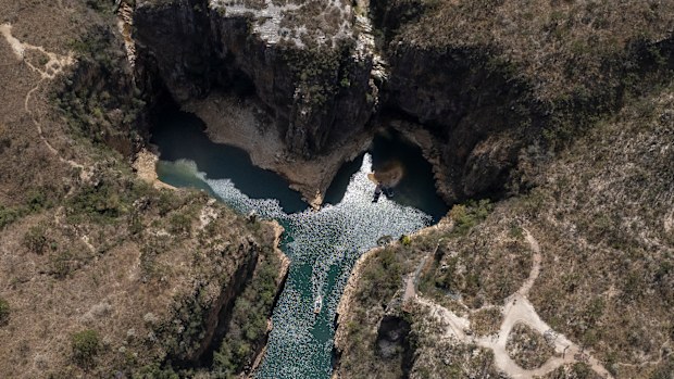 A tourist boat navigates through a canyon in Furnas Lake, near Capitolio City, Brazil. A massive slab of rock broke away from the canyon wall and and toppled onto boaters.