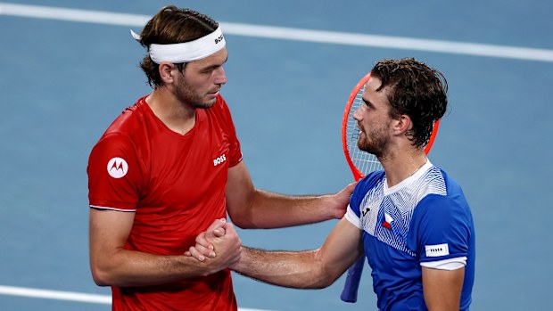 Taylor Fritz of the United States and Tomas Machac of Czechia shake hands after the latter retired from their match.