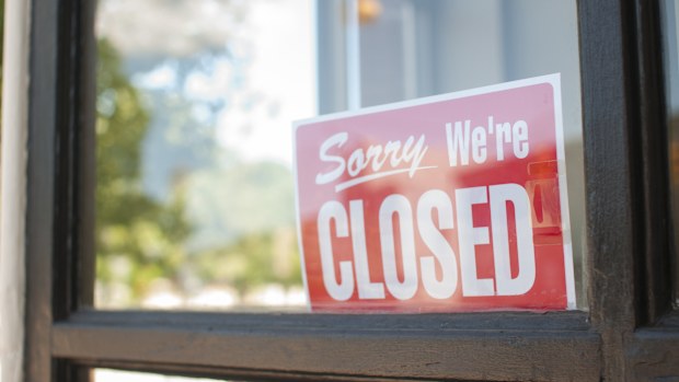 Sorry, We're Closed Sign in a small town main street  storefront window.