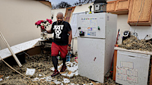 Marcus Cole finds his wife's, Tamara, undamaged roses on a kitchen table while he salvaging belongings.