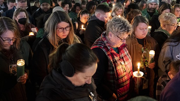 Attendees hold their heads down for a prayer during a vigil for Abby Zwerner, the teacher shot by a 6-year-old student at Richneck Elementary, in front of the Newport News Public Schools Administration Building on Monday, Jan. 9, 2023, in Newport News, Va. 