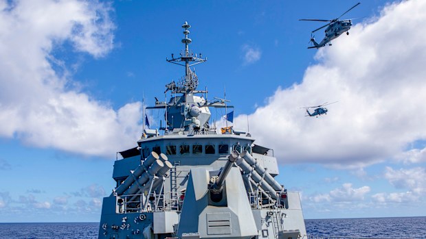 HMAS Ballarats embarked MH-60R helicopter flies in formation with a United State Navy MH-60R, off the coast of Queensland, during Exercise Talisman Sabre 2021.