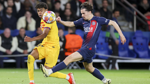 Lamine Yamal of Barcelona passes the ball alongside Vitinha of Paris Saint-Germain.